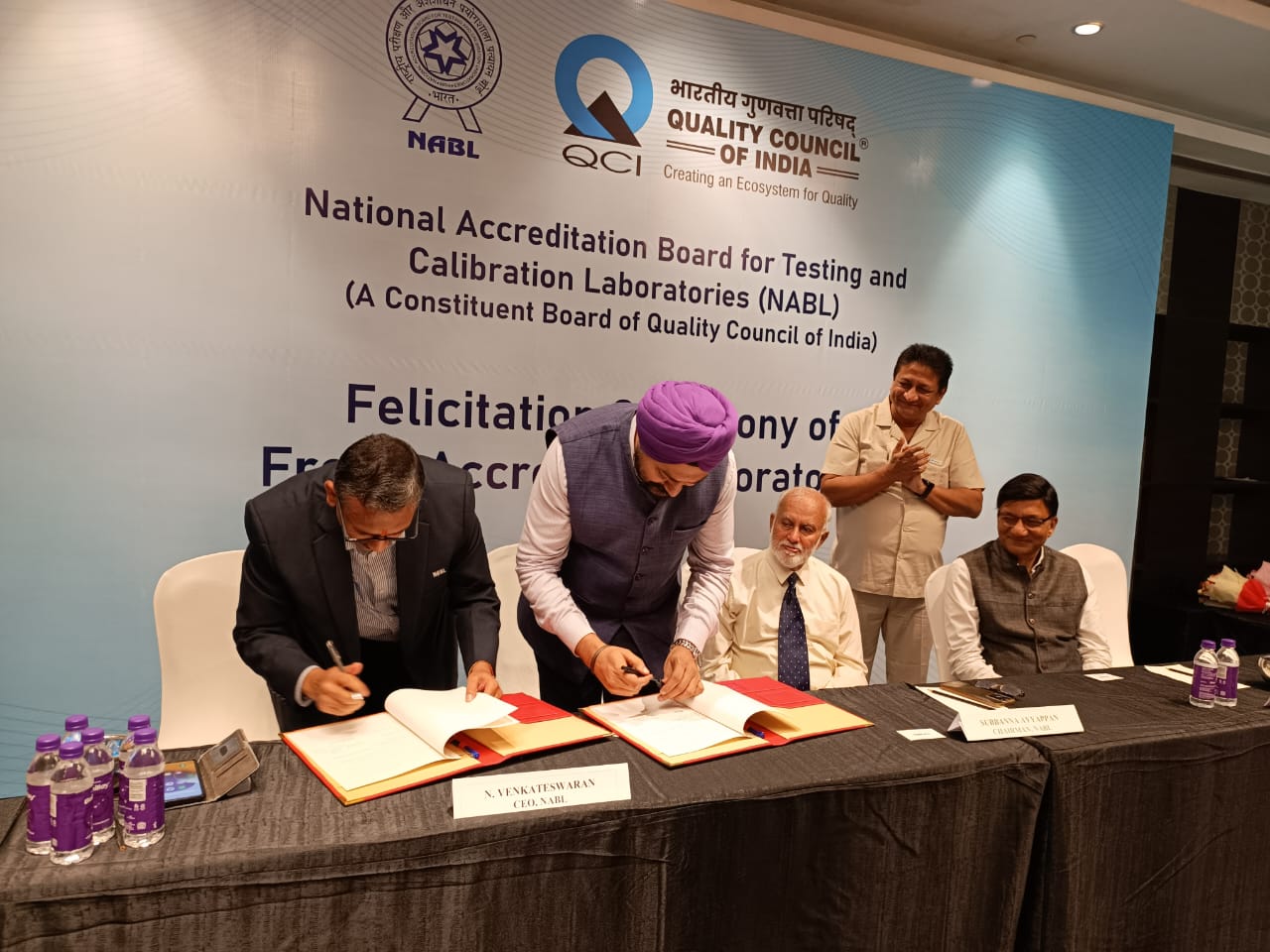 MoU is being signed between EEPC India and NABL India. On the dais two signatories- Mr N Venkateswaran, CEO, NABL India (far left) and Mr Gurvinder Singh, Sr Director, EEPC India (second from left). Mr D J Basu, Director (P&A), EEPC India & Coordinator, EEPC India Technology Centre (standing behind).