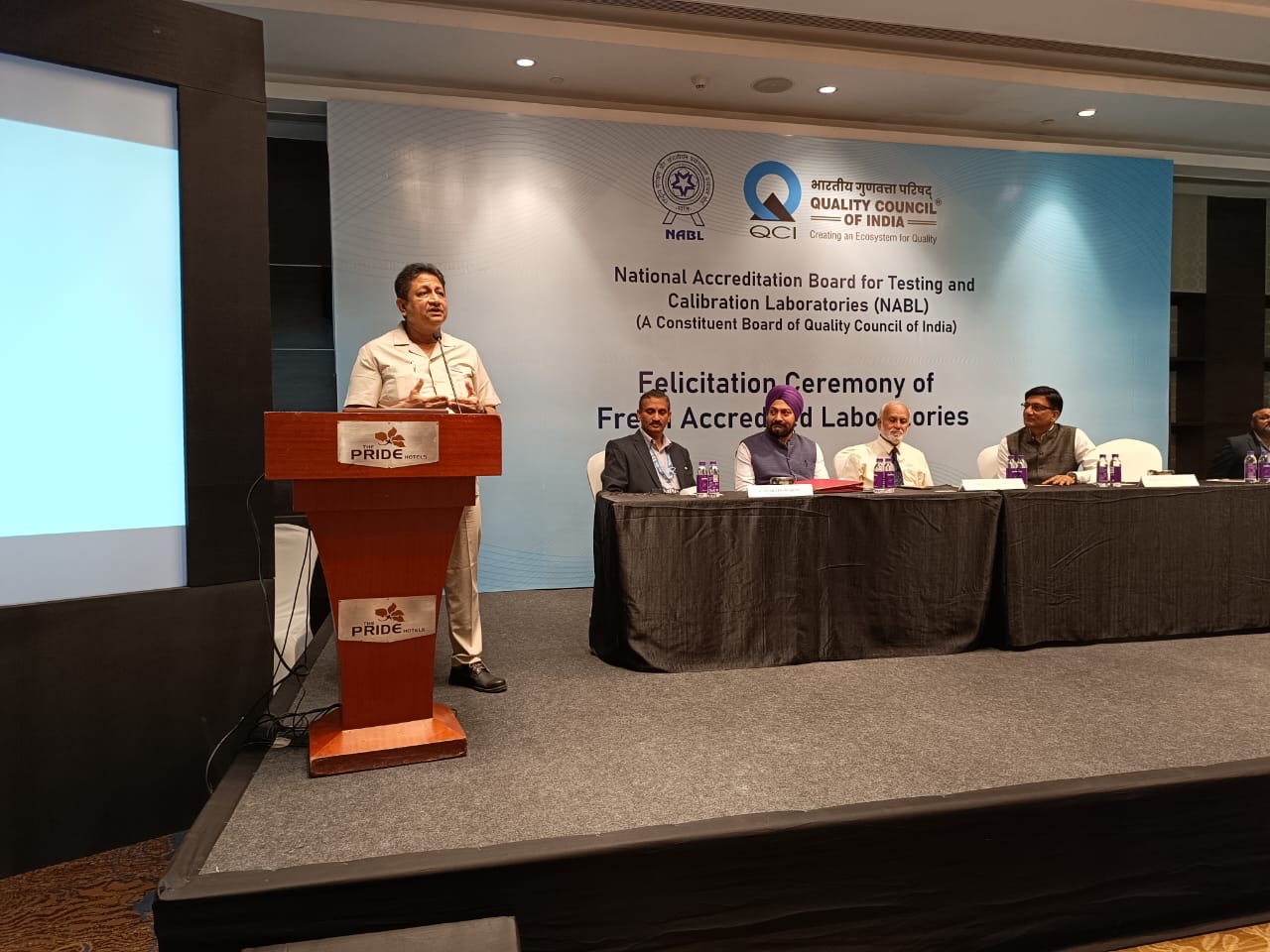 Mr D J Basu, Director (P&A), EEPC India & Coordinator, EEPC India Technology Centre (at the podium) speaking at the event. At the Head Table (from left)- Mr N Venkateswaran, CEO, NABL India; Mr Gurvinder Singh, Sr. Director, EEPC India; Padma Shri Prof. Subbanna Ayyappan, Chairman, NABL India and Dr Chakravarthy T Kannan, Secretary General, QCI.